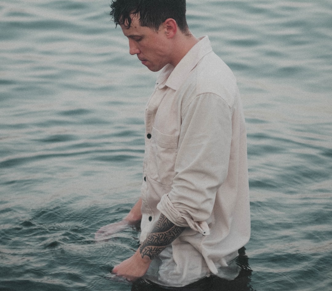 a-man-standing-in-front-of-water-i82au-cukak